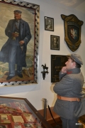Pracownik muzeum w mundurze oficera legionów w sali muzealnej